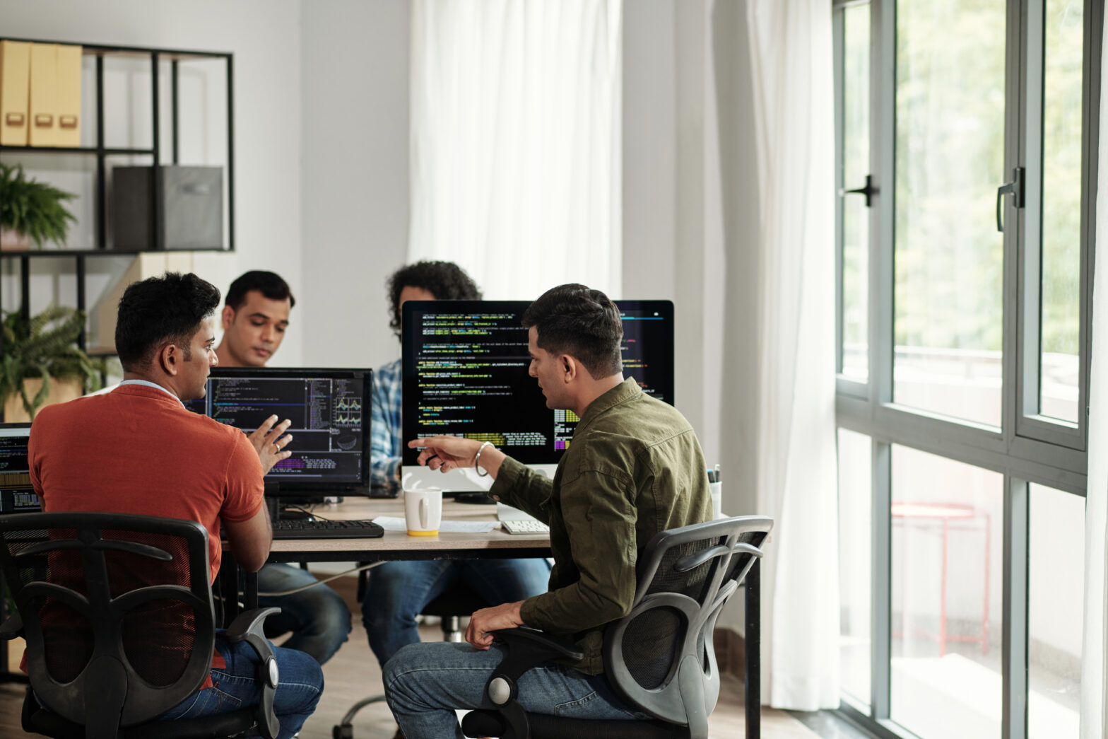 Software developers discussing programming code and planning software delivery